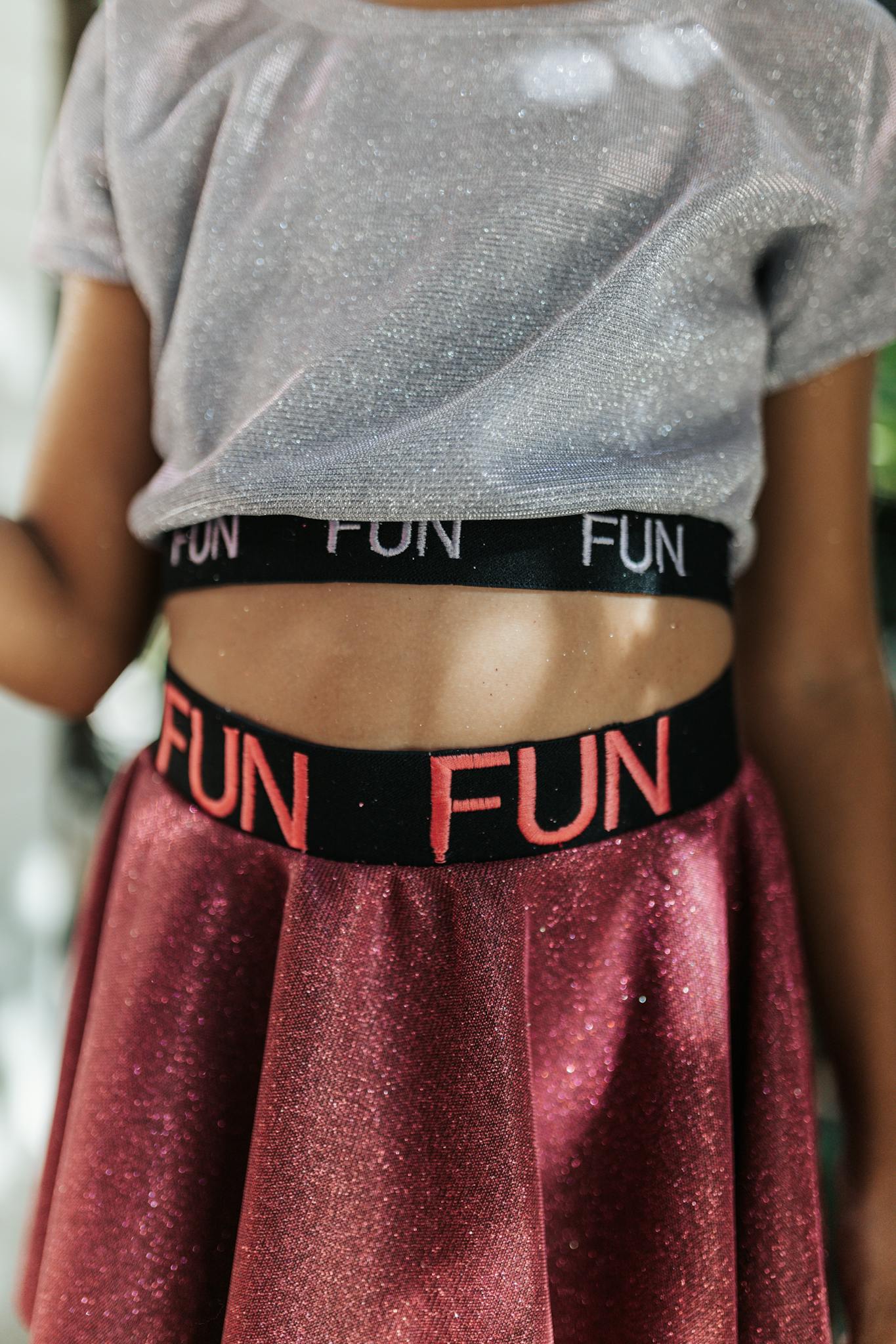 A close-up of a child wearing a glittery top and skirt, exuding fun fashion vibes.